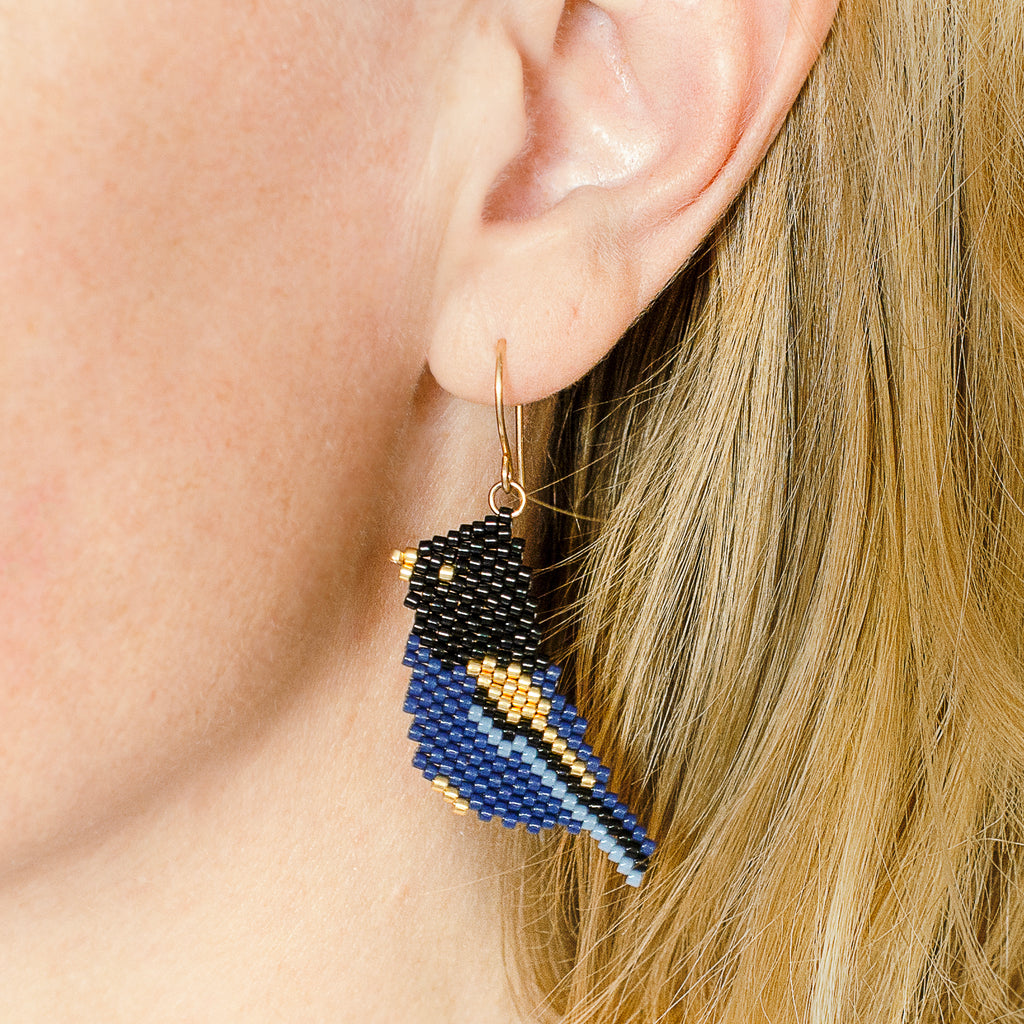 Model wearing the Cobalt Crested Steller's Jay beaded drop earrings to show how they hang